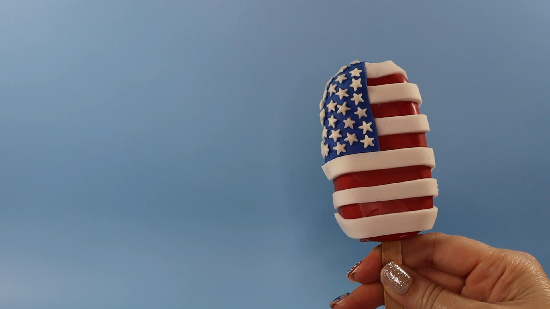make american flag red white and blue cakesicle for fourth of july by adding fondant stripes and star sprinkles