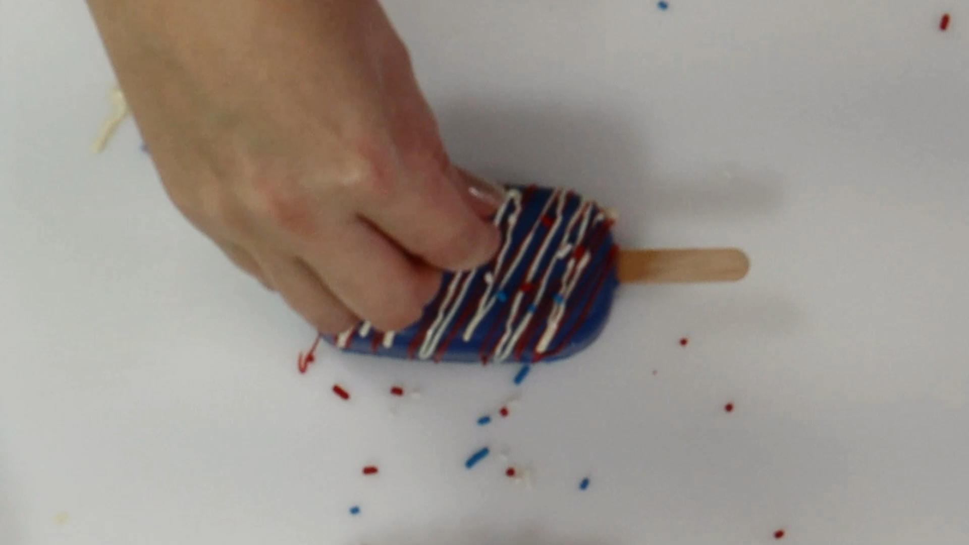 add sprinkles to your fourth of july cakesicle in red white and blue