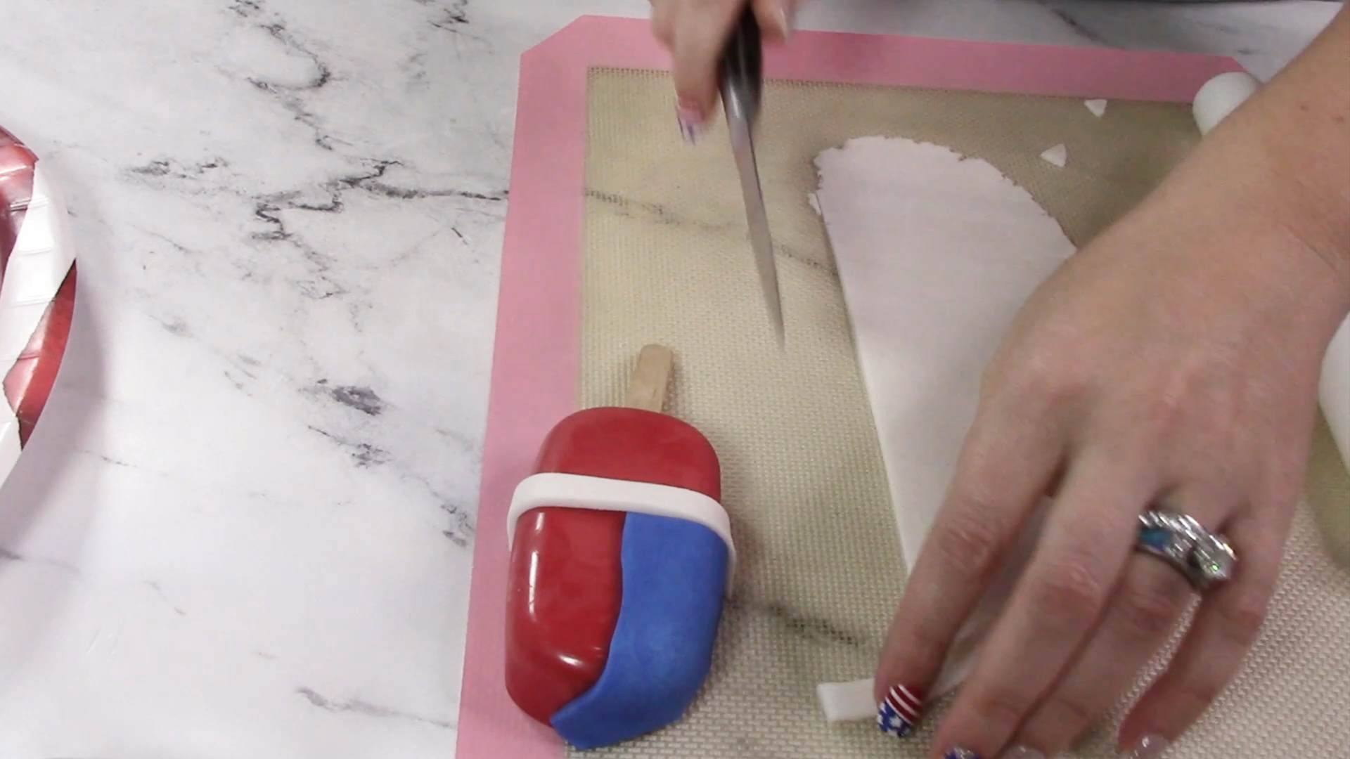 Create an american flag on the cakesicle by placing blue and white fondant on the red pop