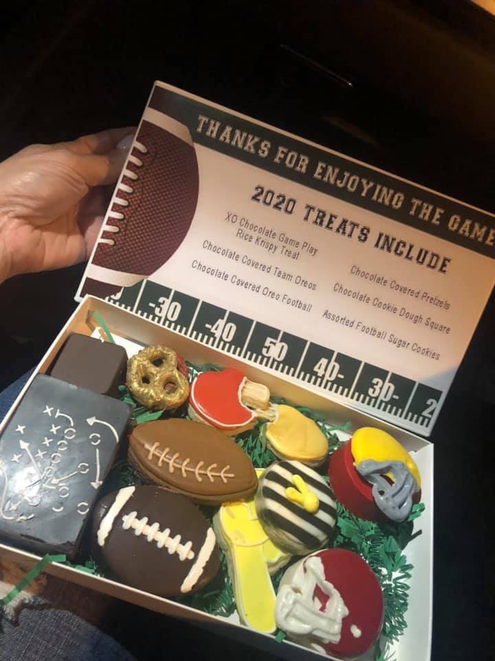 super bowl party football goodie box treats of decorated sugar cookies, chocolate covered oreos, chocolate covered rice krispy treats, chocolate covered pretzels and more